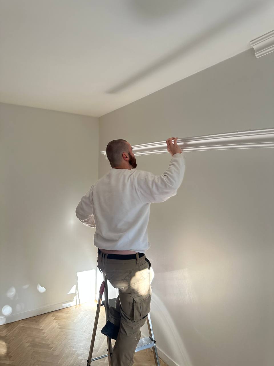 Artisan Power Paint posant une corniche de plafond